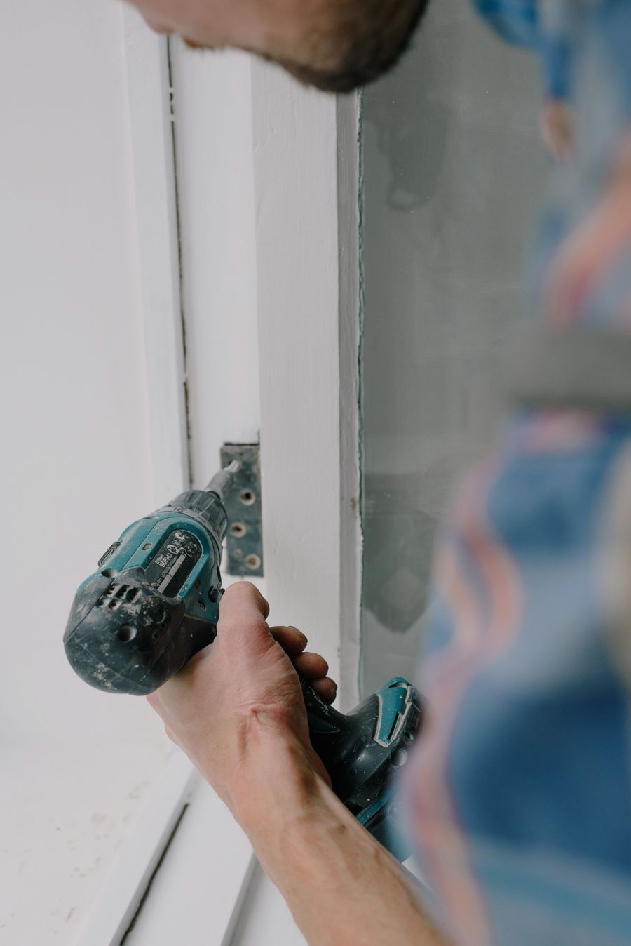 Worker drilling for a small home improvement installation